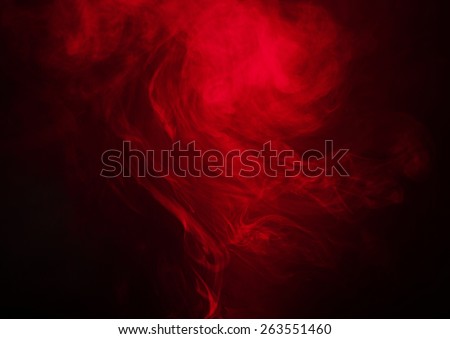 Red smoke over black studio background