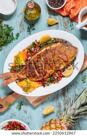 Red Snapper with ingredients. Prepared in tropical taste with Pico de Gallo and pineapple. Fresh and tasty fish and seafood. 