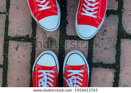Red sneakers shoes on woman's and man's feet. Sneakers shoes Couple. Copy space.