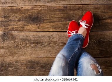 Red Sneakers Shoes Walking On Dirty Wooden Top View