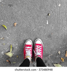 Red Sneakers Shoes Walking On Dirty Concrete Top View , Canvas Shoes Walking On Concrete Great For Any Use.