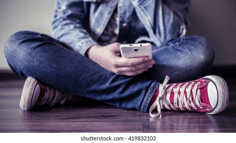 Red Sneakers. The Teenager With A Smartphone.