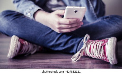 Red Sneakers. The Teenager With A Smartphone.