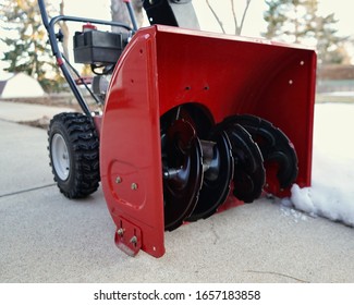 A Red Snow Blower With Black Blades