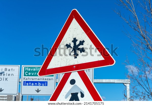 Red snowfall traffic sign. Road warning symbol\
and Snowflake icon. icy\
street.