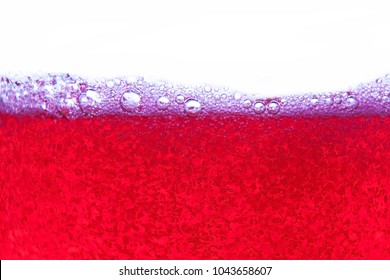 Red Soda Water Splashing With Bubbles Close Up And Dew Point On Glass