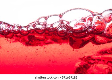 Red Soda Water Splashing  With Bubbles Close Up And Dew Point On Glass