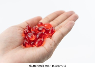 Red Soft Gel Vitamin Supplement Capsules On Palm