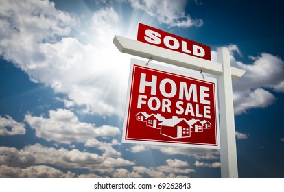 Red Sold Home For Sale Real Estate Sign Over Beautiful Clouds And Blue Sky.