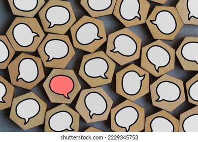 Red speech bubble surrounded by white speech bubbles. Different opinion, dissent, disagreement, important information, criticism, remark and objection concept