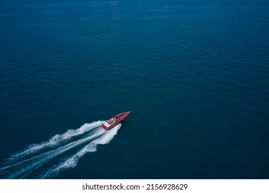 Red speed boat fast movement on the water top view. Top view of a red fast boat. Diagonal boat movement on blue water top view. Travel - image.