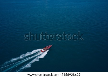 Red speed boat fast movement on the water top view. Top view of a red fast boat. Diagonal boat movement on blue water top view. Travel - image.