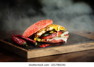 Red Spicy Burger On A Wooden Board With Smoke On Background