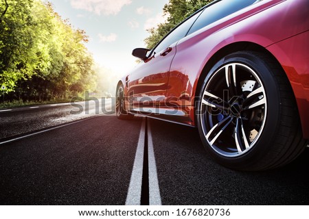 Red sport car on the asphalt road