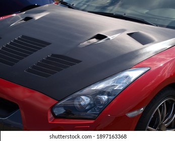 Red sportcars with carbon fiber hood.
