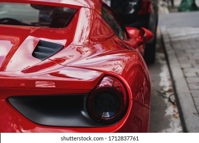A red sports car is parked on an ordinary street