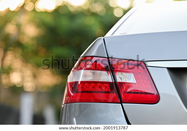 \
red sports car tail\
lights with golden yellow natural light in the morning European\
cars in Thailand