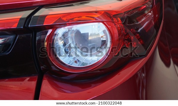 Red sports car tail lights Modern design provides\
light for safe driving, preventing accidents in traveling as a\
close-up view.