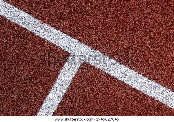 Red\
sports court or playground background with white line. Artificial\
rubber coating for playgrounds and sports\
places.