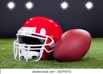 Red Sports Helmet Lying On Green Grass Field - Powered by Shutterstock