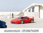 Red sports racing car. Low classic car. Legend of motorsport. Aerodynamics, wheel disks. Bright body. Futuristic design. Very expensive hypercar.