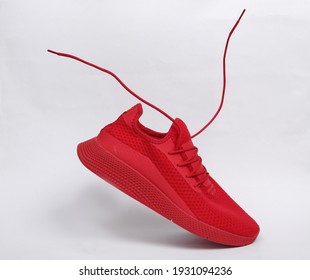 Red Sports Shoe With Flying Laces On White Background