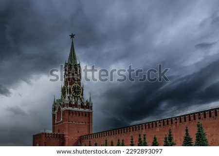 Red Square. Spasskaya tower with a clock on a background of cloudy sky. Gathering clouds over the Kremlin. Moscow, Russia.