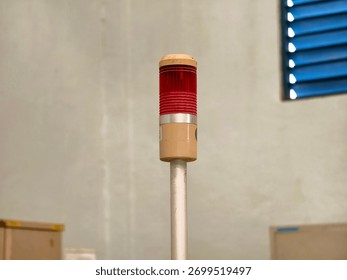A red stack light illuminates providing a visual indication of the status or condition of machinery or equipment in an industrial setting. Safety and alert system.