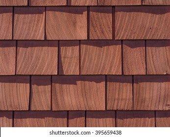 red stained wall of cedar wood shingles background