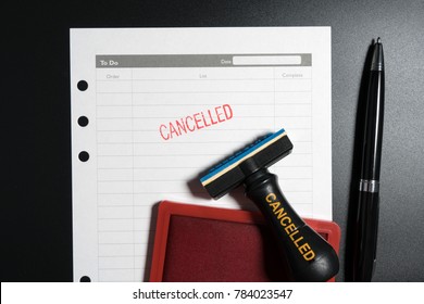 Red Stamp With Text Cancelled On Business To Do List Table On Black Background. Reminder To Cancel Business Appointment. Business Cancelled Rejected Abort Declined Cancellation Denied Concept.