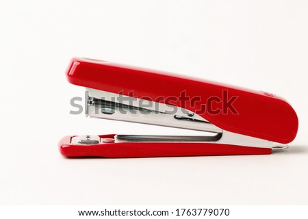 Red stapler on a white background.