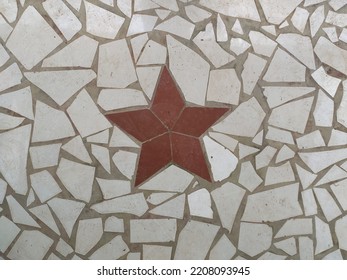 Red Star Design Isolated On Interior Floor Decorated With White Broken Or Cracked Waste Ceramic Or Mosaic Tile Pieces. Old Vintage Architecture Tiling Art Background Texture Pattern. Closeup View.