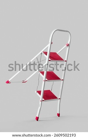 Red stepladder on light background