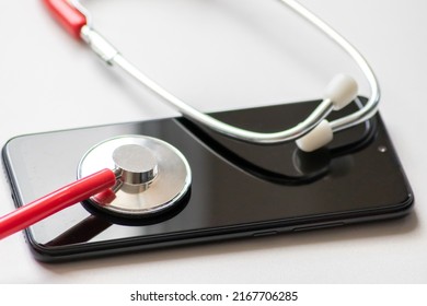 Red Stethoscope On Black Smartphone Represents Health Records And Digital Patient Records With Mobile Devices For Digital Doctors And Digital Diagnostic Treatment With Modern Equipment And Technology