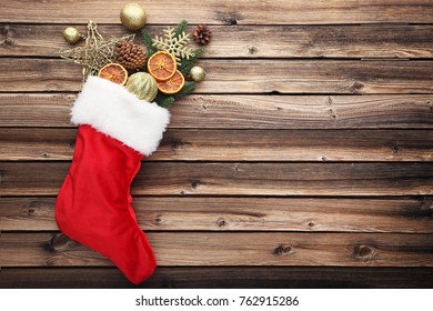 Red stocking with christmas decorations on wooden table