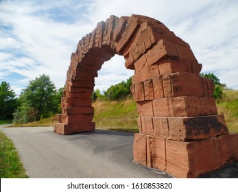 Red Stone Man Made Arch Against Cloudy Blue Sky in the Park