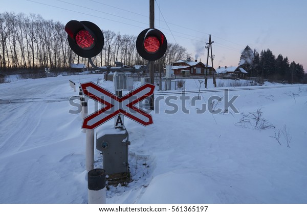 Red stop\
lights and road sign at railroad crossing. Ostashkovskiy district,\
Tver oblast, Russia, January\
2017.