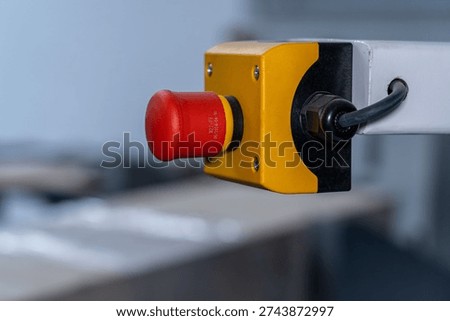 Red Stop Push Button on Yellow Black Industrial Enclosure