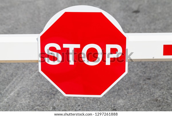 Red stop road\
sign mounted on street\
barrier