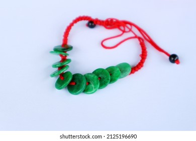 Red String Bracelet With Green Stone. Isolated On White Background.