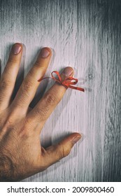 Red String Tied Around A Finger. Memory And Reminder Knot.