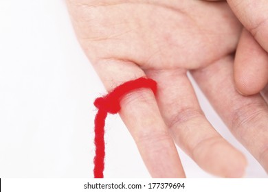 Red String Of Wool Around Finger