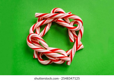 Red Striped Candy Canes Shaped as a Christmas Wreath in a Circle on a Green Background.  - Powered by Shutterstock