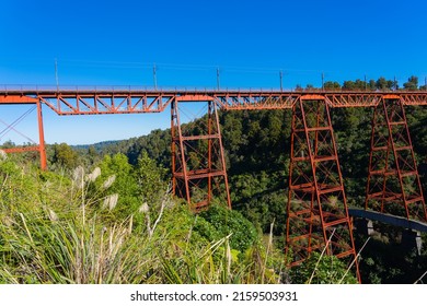 Red Structure Of Makatote Viaduct, Bridge Number 179, Against New Zealand Bush On Main Trunk Line In North Island.