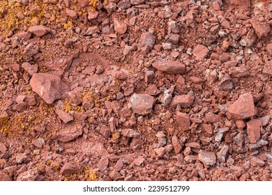 Red subsoil texture background. Dirt in nature. Red hard and compact soil at construction site. 
Subsoil layer. Geology. Underground earth. Sand stone rock. Geological sciences. Geological engineering - Shutterstock ID 2239512799