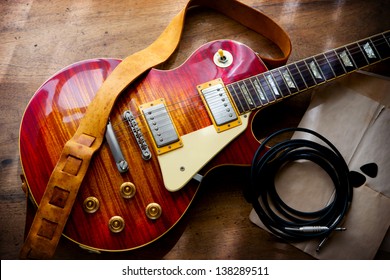 Red sunburst solid body electric guitar, in backstage or studio style setting. - Powered by Shutterstock
