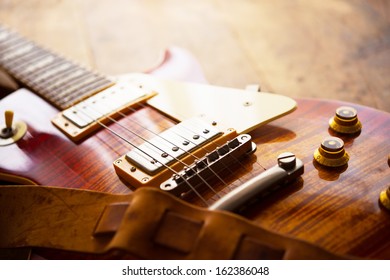 Red Sunburst Solid Body Electric Guitar With Well Used Leather Strap.