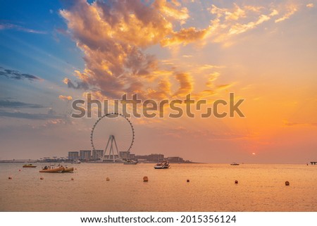 Red sunset over Bluewaters Island with the famous Dubai Eye Ferris wheel. Panoramic view of the city and nature in UAE