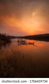 山火事の後の煙の中の赤い夕日 夕暮れ時に川の中の枯木の形で壁紙を貼る 写真素材 Shutterstock