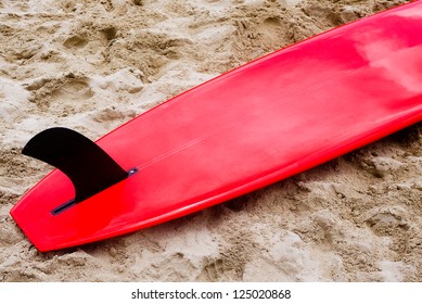 Red Surfboard With Black Fin